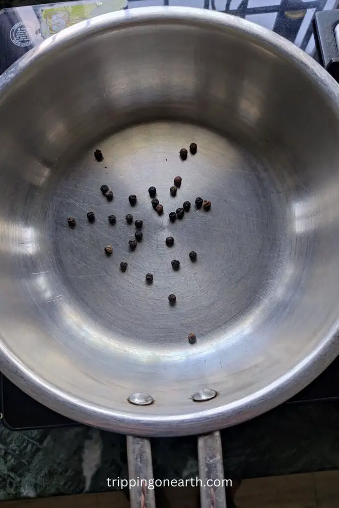 heat black peppercorns in a pan