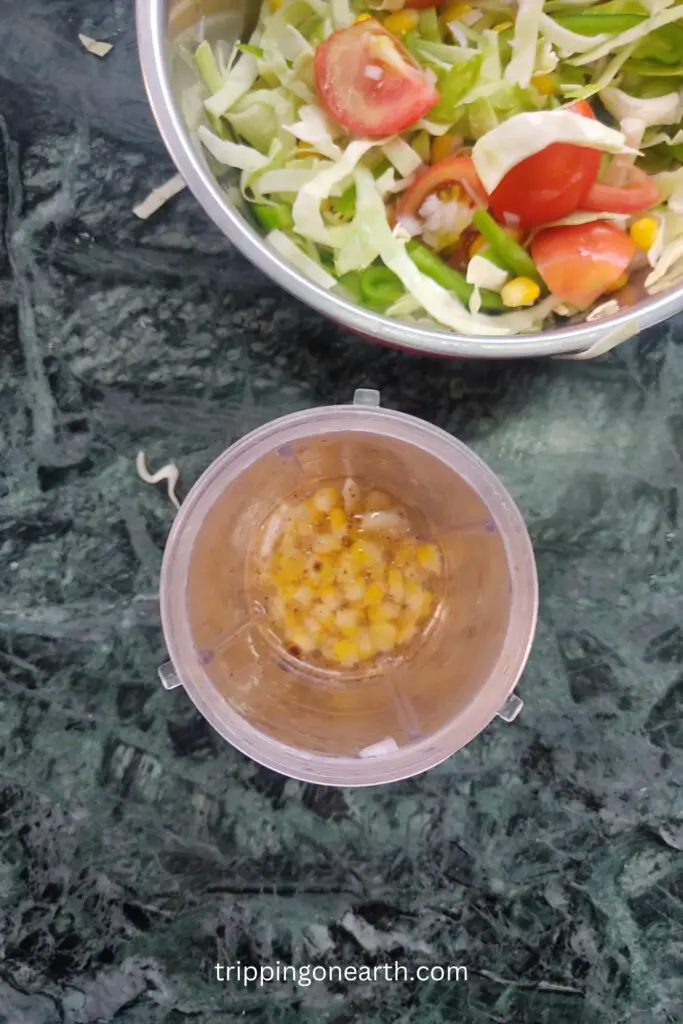 corn, garlic, oil, salt, pepper, lime juice, and vinegar in a blender