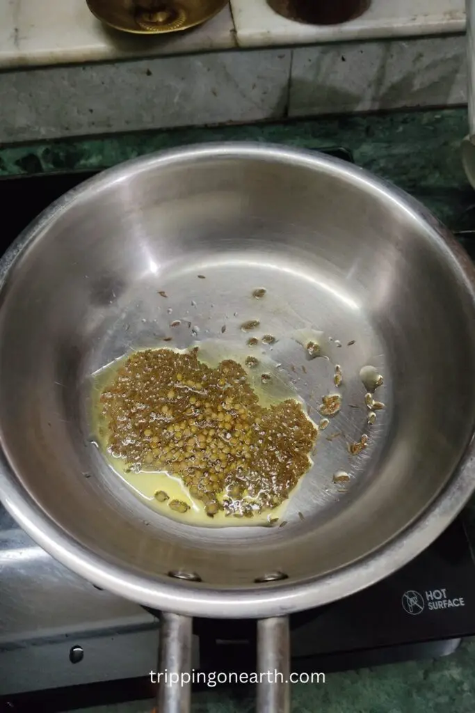 coriander seeds and cumin seeds in hot oil in a pan.