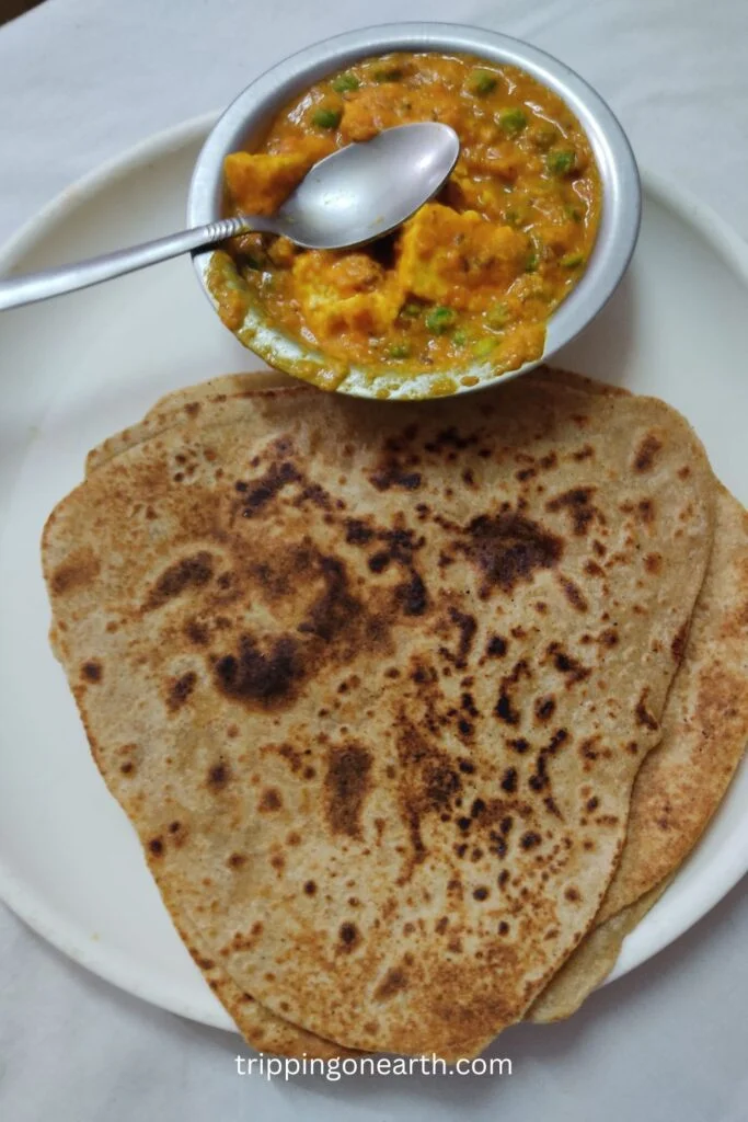 matar paneer without onion and garlic on a plate along with parathas