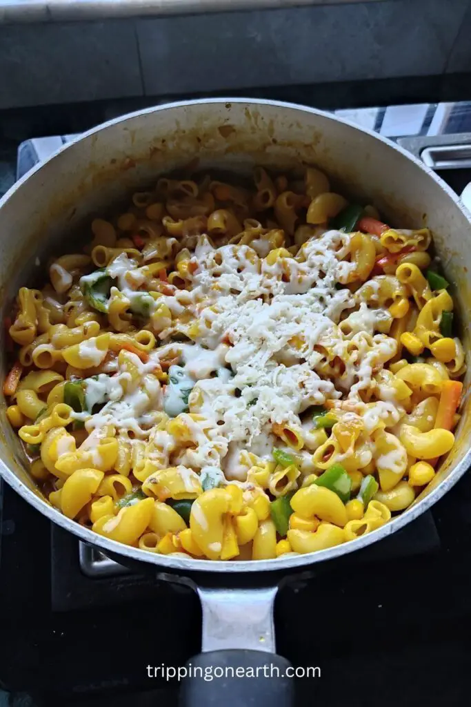 processed cheese shredded over the macaroni masala