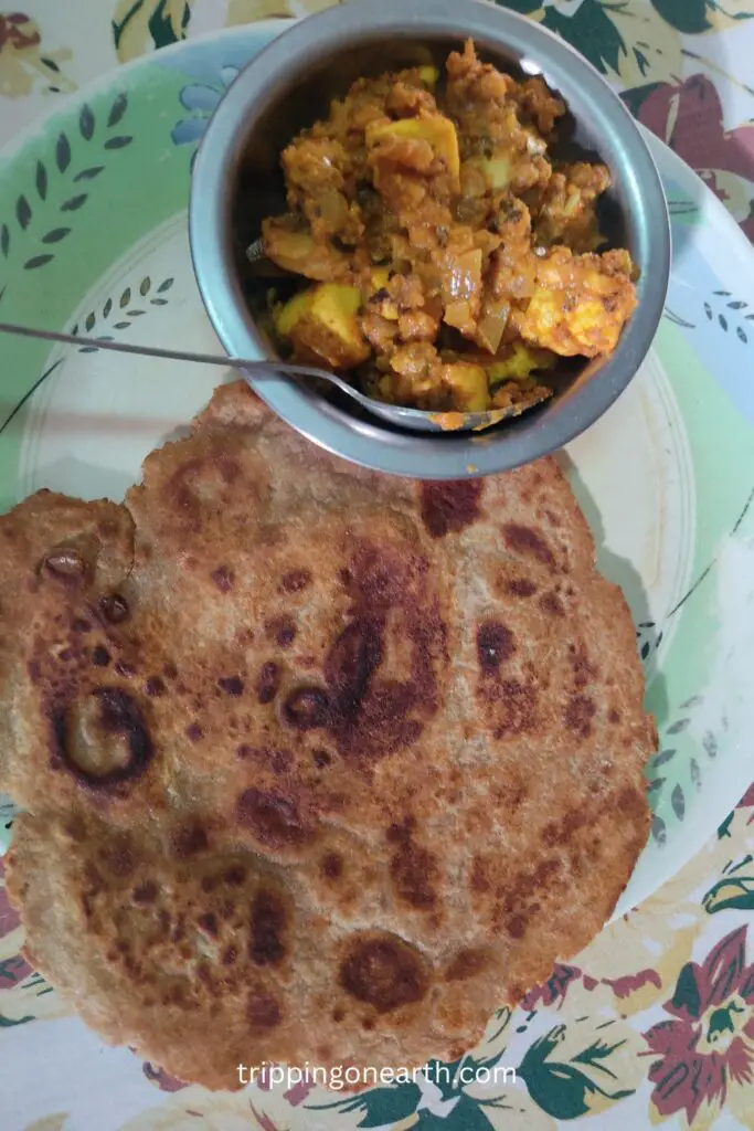mushroom paneer in a bowl on a plate along with paratha