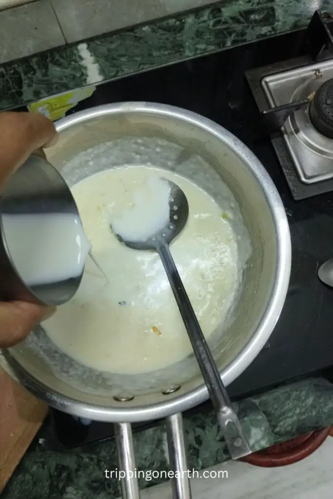 pouring milk from a glass in the skillet, and frying strainer resting on the skillet