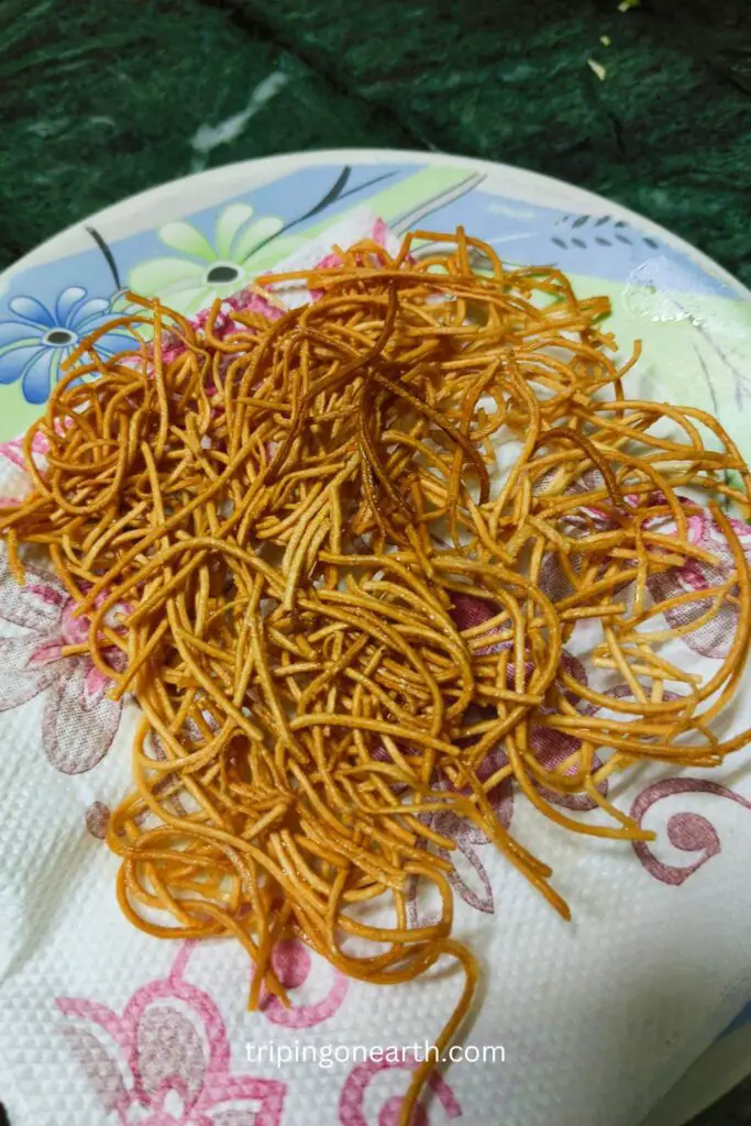 fried noodles on a napkin placed on a plate