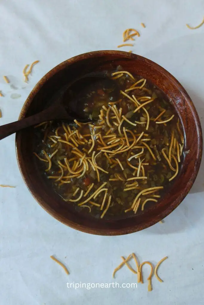 veg manchow soup in a wooden bowl and a wooden spoon