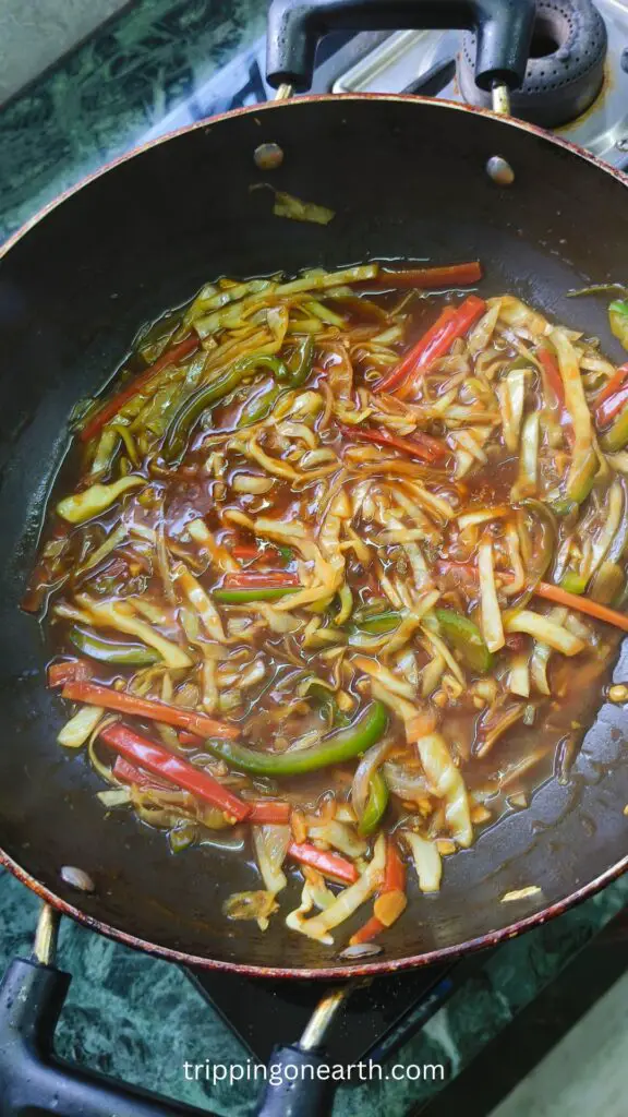 veggies mixed with the sauce in a wok