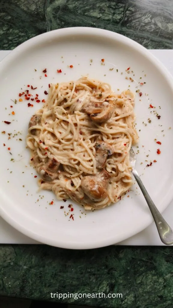 mushroom alfredo pasta on a white plate