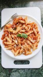 marinara sauce penne pasta on a white plate