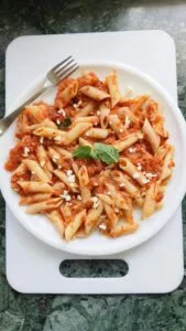marinara sauce penne pasta on a white plate