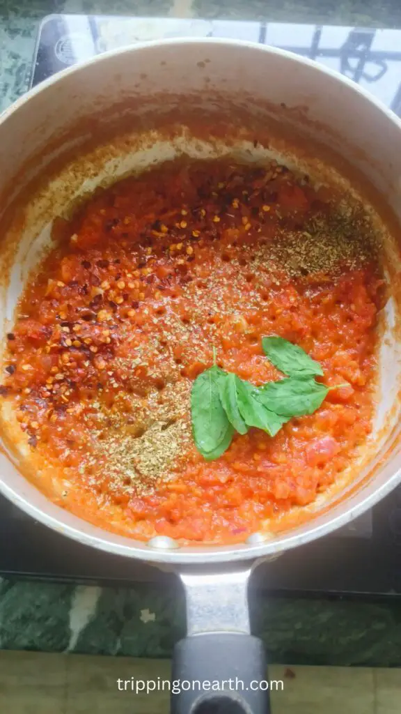 red chili flakes, oregano, basil leaves, added  to the tomato puree in a skillet