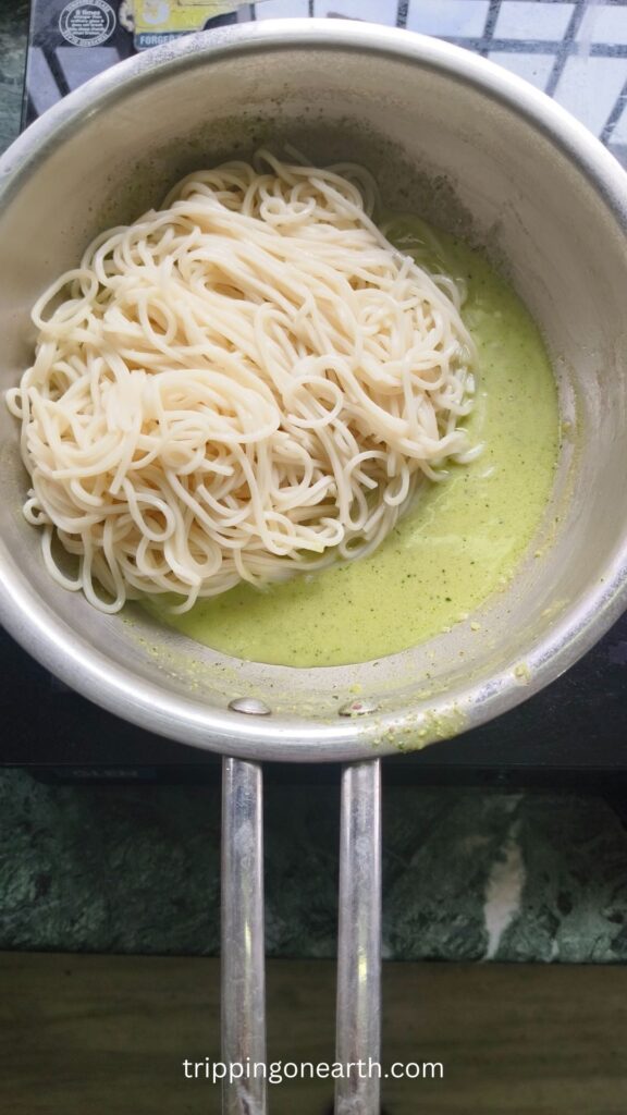 spaghetti pasta on top of lemon pesto sauce in a skillet