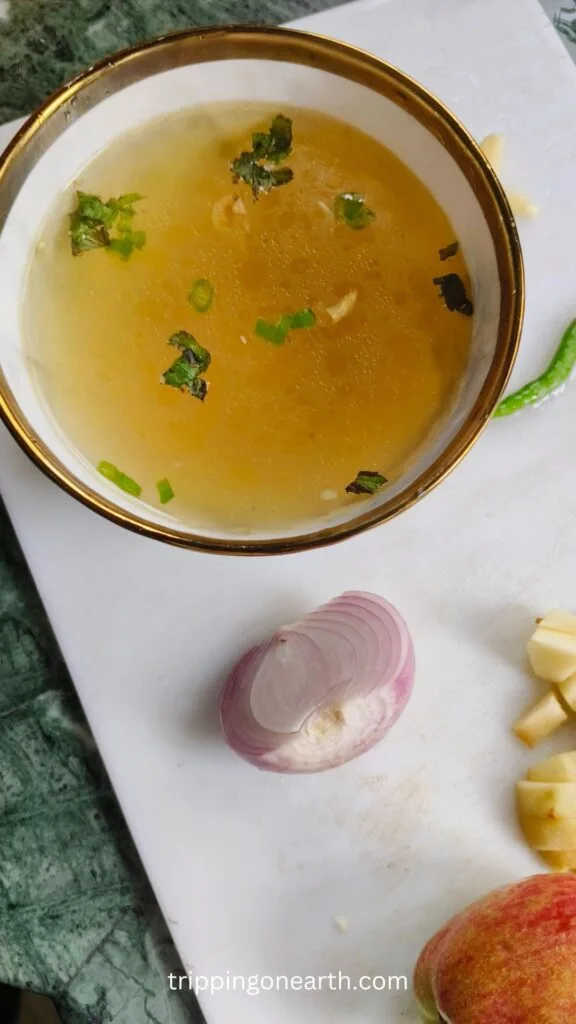 Clear soup in a white bowl