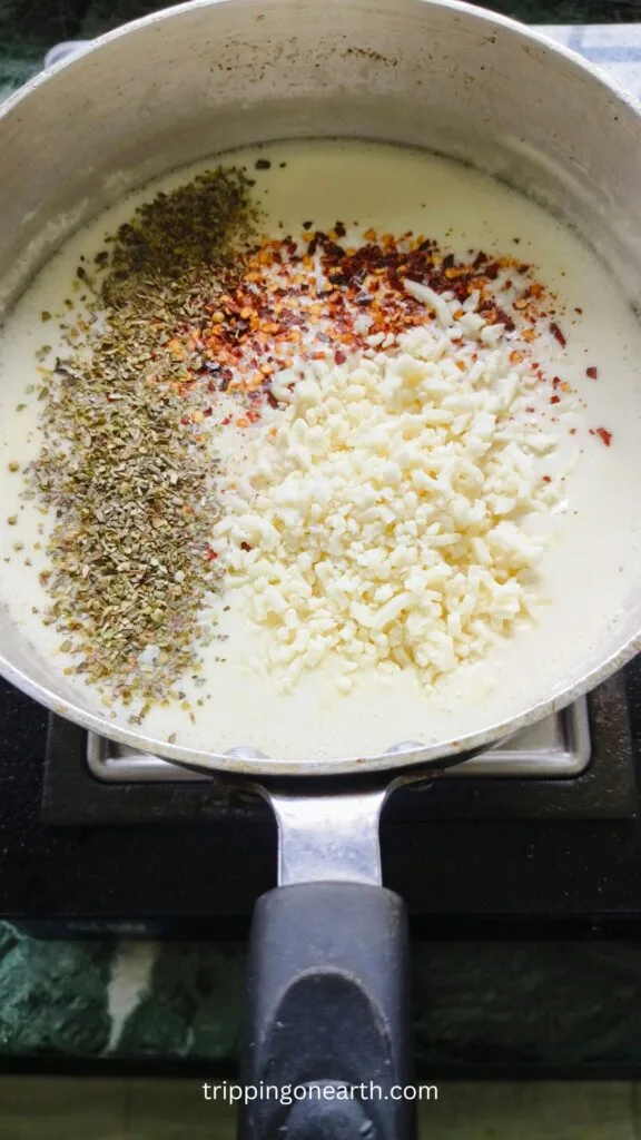 Oregano, red chili flakes, and mozzarella sprinkled over the sauce
