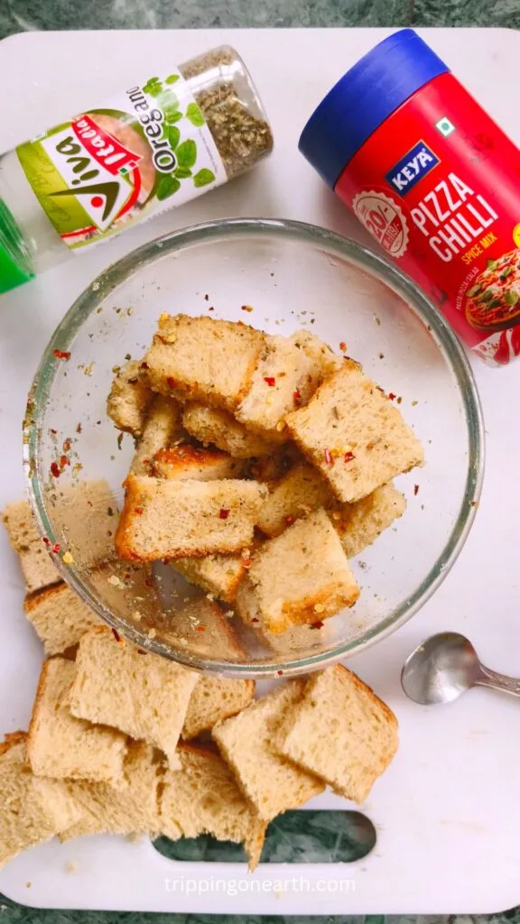 Bread mixed with seasonings in a mixing bowl