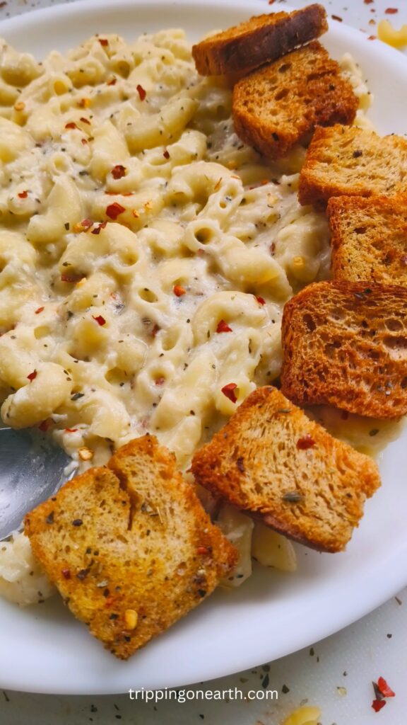 White cheddar mac and cheese with croutons on a white plate