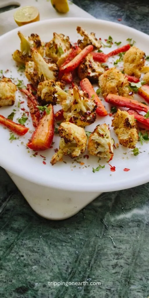 Roasted cauliflower and carrots on a white plate