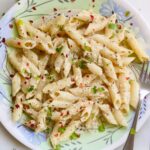 Lemon pepper pasta on a plate along with a fork