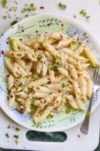Lemon pepper pasta on a plate along with a fork